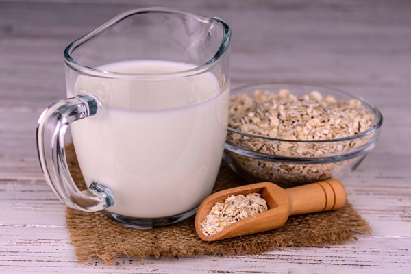lactosefree oat milk in a glass decanter on a white background - Смузи-боул с постным кокосовым йогуртом