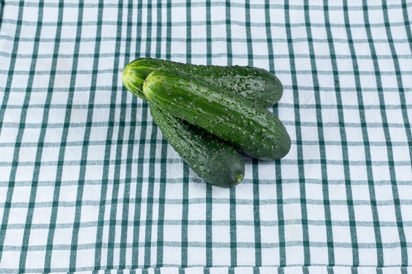 three fresh cucumbers isolated on a tablecloth high quality photo - Постный смузи-боул с огурцом, авокадо, спаржей и киви