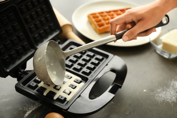 woman preparing wafers in waffle iron at home - Венские вафли в электровафельнице