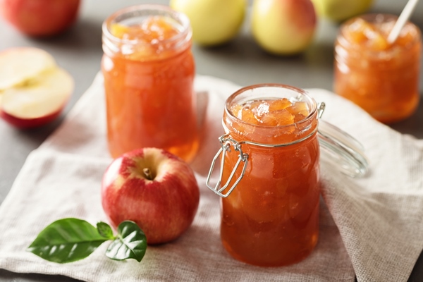apple jam in a glass jar apple jam on a light background delicious natural marmalade - Консервирование пищевых продуктов