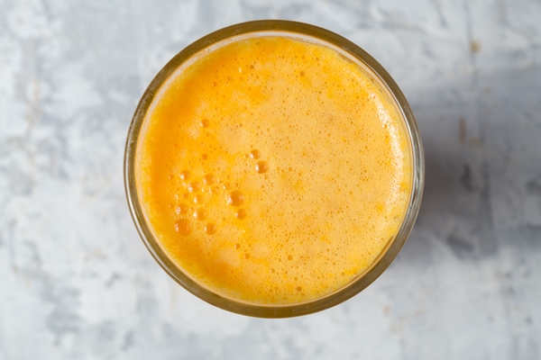 orange juice in a glass over white rustic background - Драники с апельсиново-клюквенным соусом