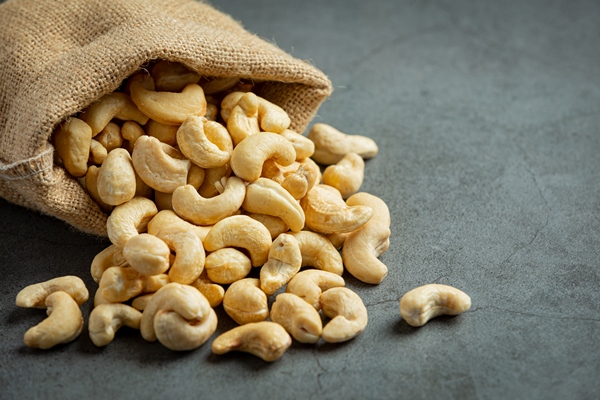 raw cashews nuts in bag on dark background - Постный пудинг из кешью