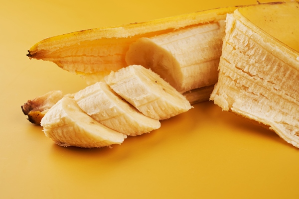 sliced bananas on yellow background close up healthy dessert ingredient - Смузи-боул со шпинатом и авокадо