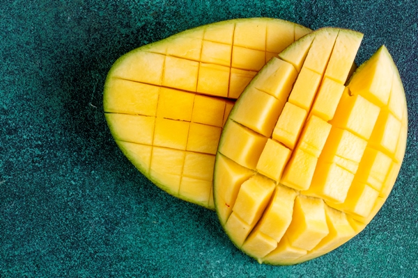 top view copy space sliced mango on green - Смузи-боул со шпинатом и авокадо