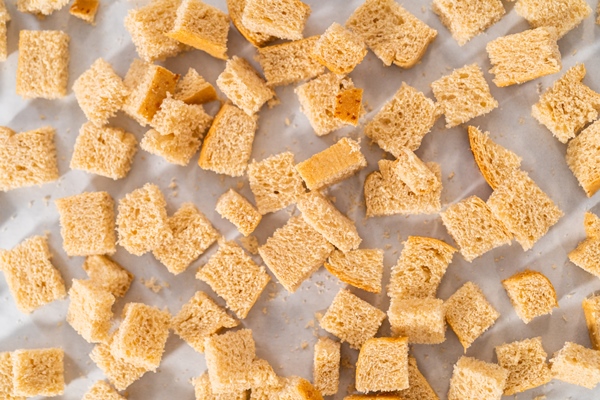 baking croutons seasoned with olive oil and spiced on a baking sheet lined with parchment paper - Тюря острая