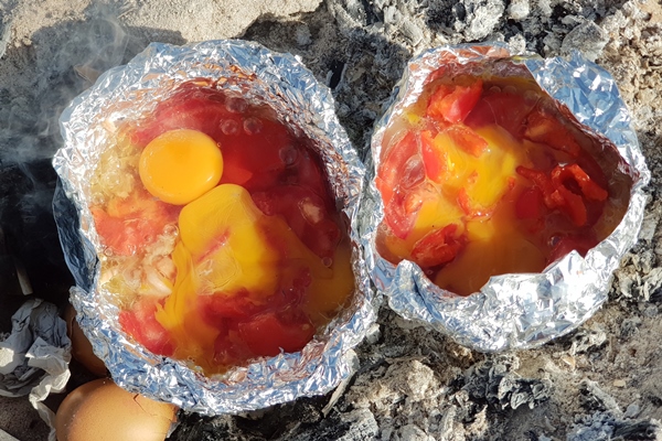 cooking of eggs with tomatoes in foil on a fire on the beach - Организация трапезы в походе: хранение продуктов, походная кухня, утварь, меню