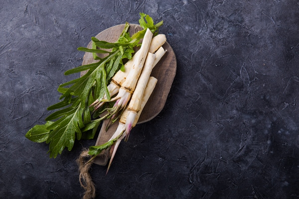 fresh orgaanic horseradish or horse radish root on wooden cutting board top view - Тюря