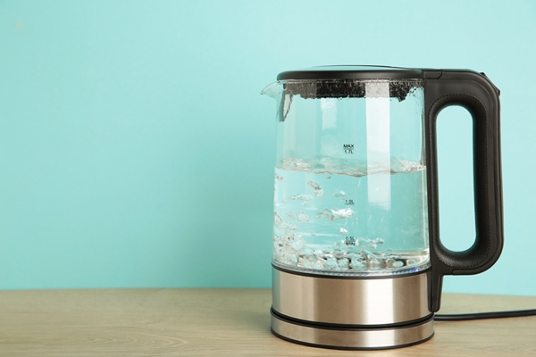 glass electric kettle with boiling water on blue background - Просфоры на заварной опаре