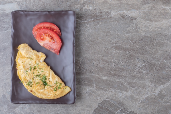 homemade tasty omelette with tomato on dark plate - Туристический омлет в пакете