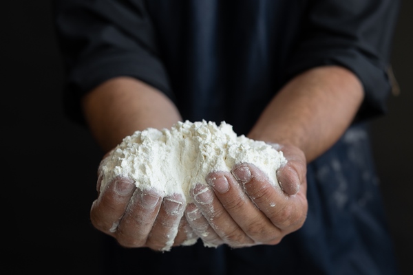 male chef male hands are holding a big handful of flour on a black table bakery concept 1 - Просфора (рецепт № 2)
