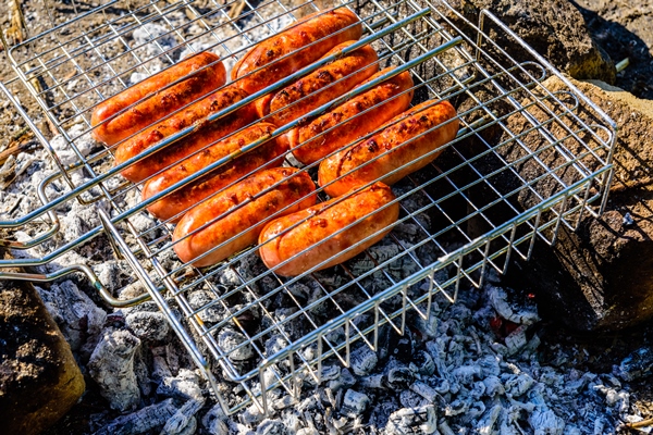 sausages cooking in a barbecue grill on campfire - Организация трапезы в походе: хранение продуктов, походная кухня, утварь, меню
