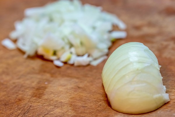 sliced onions on a wooden background - Котлеты из риса и консервов