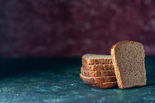 top view of dietary black bread slices on the left side on mixed colors background with free space - Маканка (макаловка)