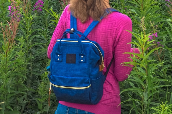 woman on a flowering field willow herb travel concept with a light backpack - Иван-чай