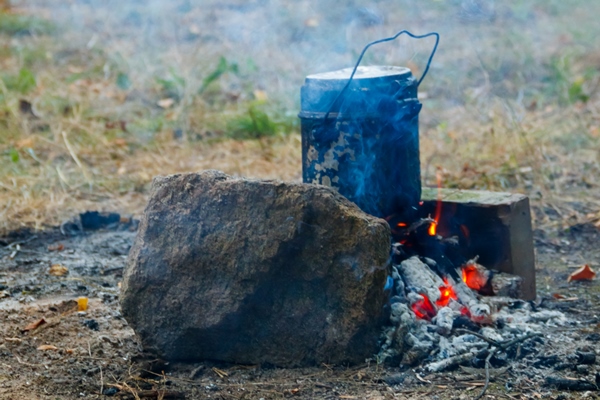 cooking on campfire in camping tent and backpack on background - Шурпа "Туристическая"