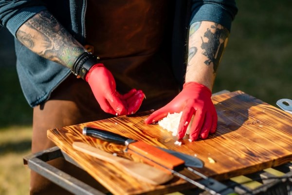 tattooed chef with rubber gloves chopping onions outdoors 636803 377 - Туристический грибной суп
