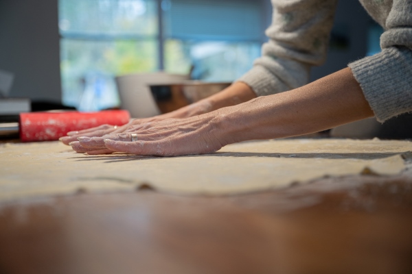 female hands stretching rolled pastry dough for strudel - Мандрики с вишней