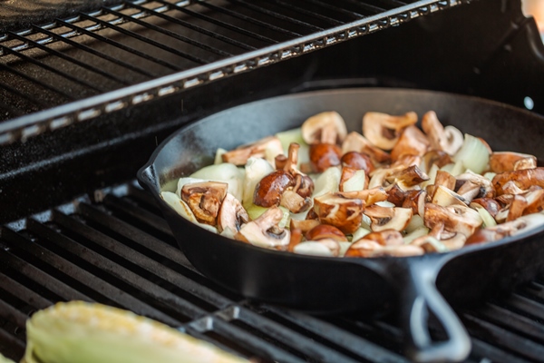 step by step grilled mushrooms and onions in cast iron frying pan on outdoor gas grill - Макароны с тушёнкой и лесными грибами на костре