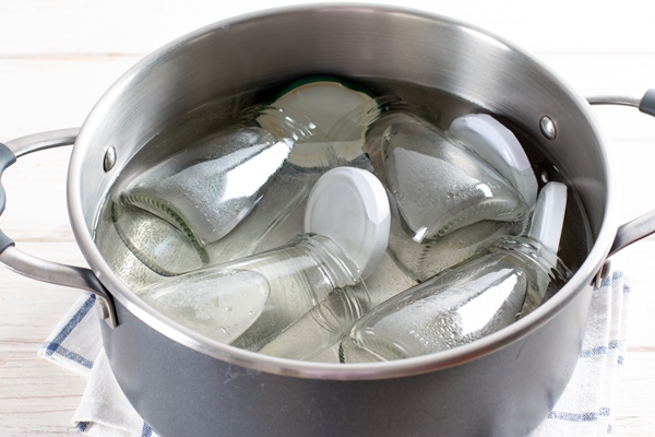 sterilizing glass jars in a steel pan steaming bubbling wather 1 - Варенье "Пятиминутка" из клубники