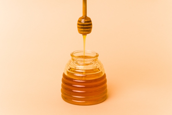 jar of honey isolated on beige background - Постный маковый рулет с мёдом и изюмом