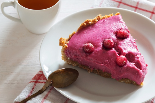 vertical photo of cranberry tart with berries spoon and tea - Мочёная брусника