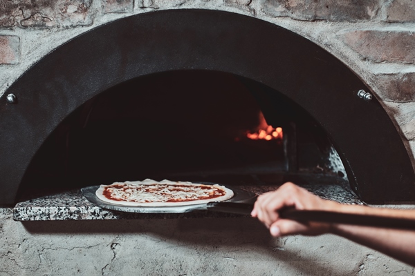 italian chef is putting prepared margarita pizza to the oven with flame in it - Пицца "Маргарита"