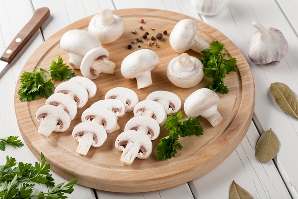 raw champignon mushrooms on cutting board - Пицца из кабачков с грибами