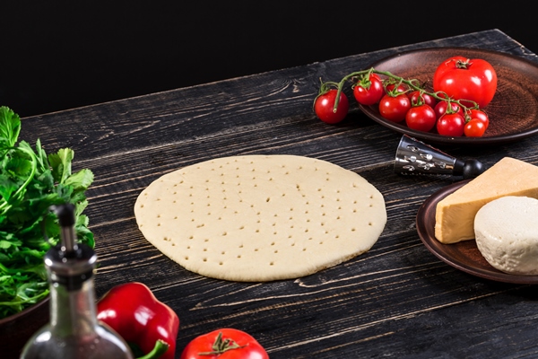 raw dough for pizza preparation with ingredient tomato sauce mozzarella tomatoes basil olive oil cheese spices served on rustic wooden table flat lay style italian pizza - Пицца "Маргарита"