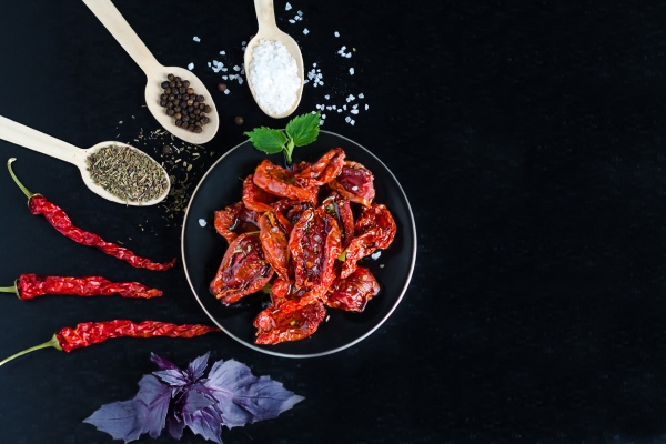 top view flat lay of process of cooking sun dried tomatoes in bowl ingredients and spices for snack on black background with copy space place for - Походный лагман из сушёных продуктов