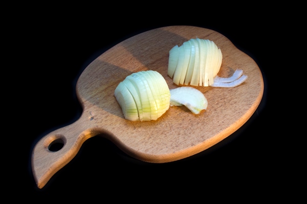 cut onions on a wooden kitchen board on a black background - Пицца с морепродуктами