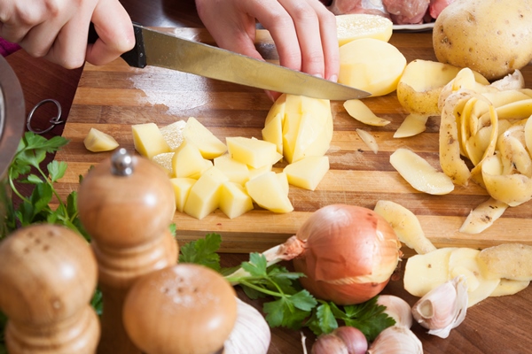 female hands cutting potatoes - Куриный суп-затируха на яйцах