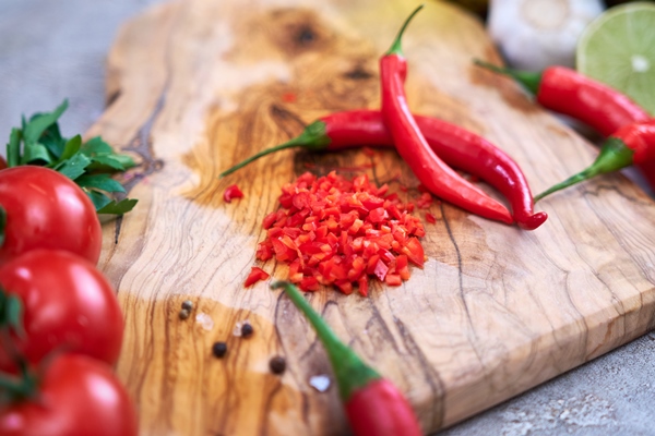making salsa dip sauce sliced and chopped chili pepper on wooden cutting board - Пицца "Сицилийская"