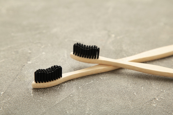 bamboo wooden toothbrush with black brush bristles on grey background - Секреты приготовления яиц всмятку, "в мешочек" и вкрутую. Пошаговая инструкция