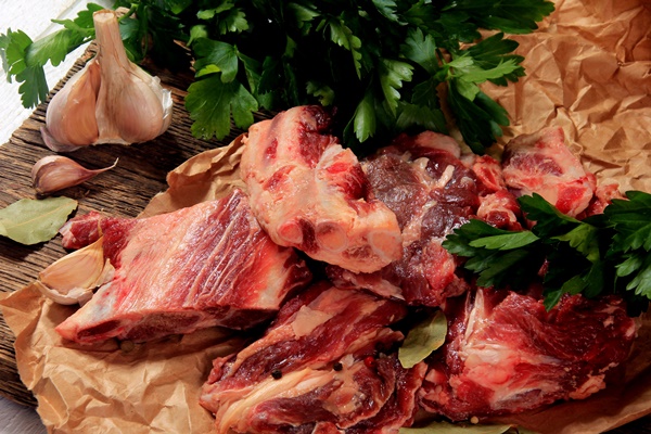 beef bone selection for soup fresh pieces of meat with bones with spices parsley and bay leaves - Старинные секреты приготовления мясных бульонов
