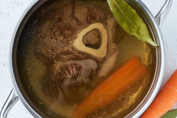beef meat broth ossobuco on bone rich soup in saucepan long slow languishing cooking - Старинные секреты приготовления мясных бульонов
