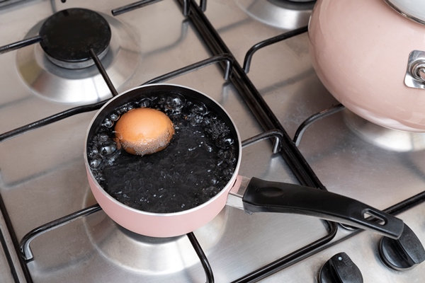 boiling chicken egg in metal pot close up - Секреты приготовления яиц всмятку, "в мешочек" и вкрутую. Пошаговая инструкция