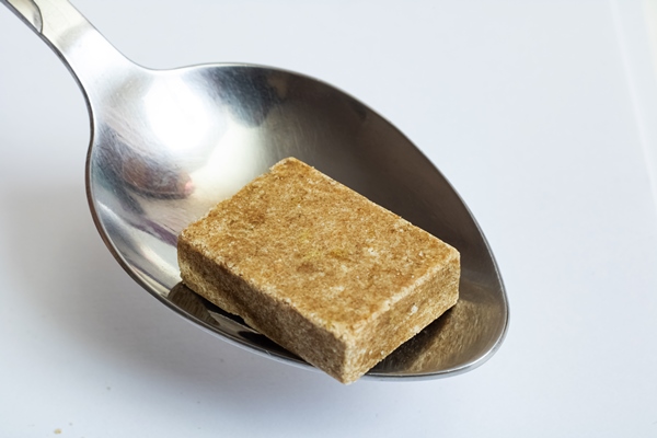 bouillon cube in a spoon close up - Старинные секреты приготовления мясных бульонов