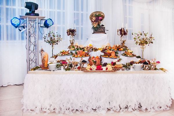 buffet table with meat snacks baked pigs in dough cheese turkey with fruit decorated with candelabra and gramophone - Рекомендации по расчёту банкетных блюд и напитков