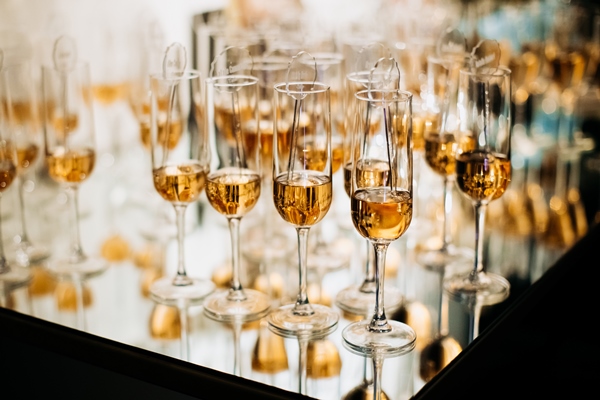 champaigne glasees full of alcohol drinks on the tray with mirroir reflection - Рекомендации по расчёту банкетных блюд и напитков