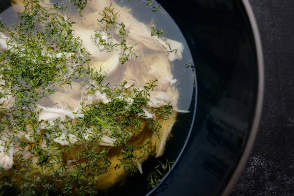chicken broth with dill consomme on a dark background - Красный сборный бульон по-румынски
