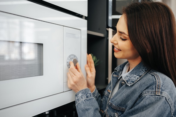 close up of a woman checking new microwave oven in hypermarket - Кулинарные секреты для одиноких
