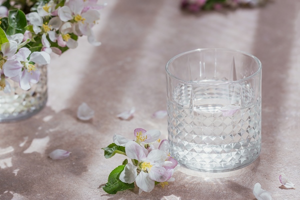 glass of pure water on the table with blossoming apple tree branch in a glass morning sunshine mood - Рекомендации по расчёту банкетных блюд и напитков