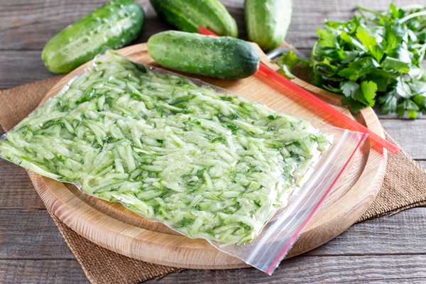 grated cucumber in a plastic bag ready to be frozen on a wooden table frozen food concept - Кулинарные секреты для одиноких