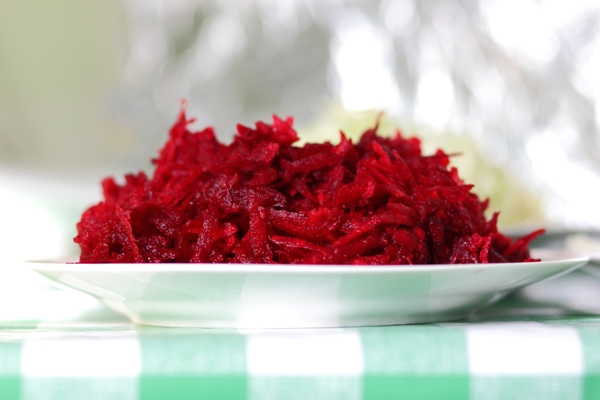 grated red beets on a plate on a tablecloth in a home kitchen healthy food concept closeup - Борщ постный из карасей