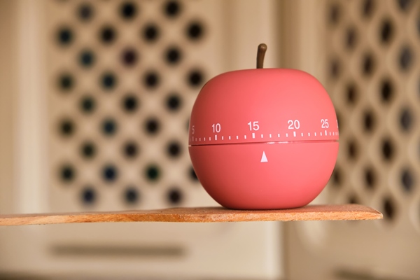 kitchen timer shaped a apple stands on wooden spatula for cooking or baking in the kitchen - Кулинарные секреты для одиноких
