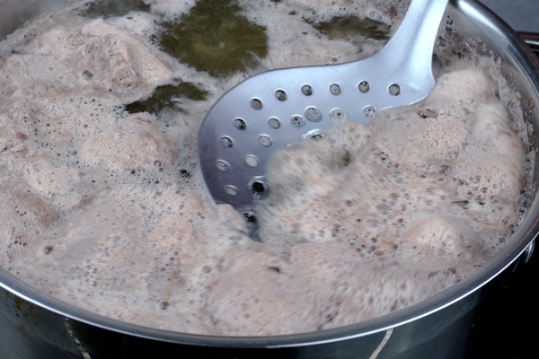 meat broth with abundant foam boils in saucepan foam is removed with metal slotted spoon - Старинные секреты приготовления мясных бульонов
