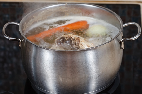 simmering chicken soup in pot on cooker close up - Красный сборный бульон по-румынски
