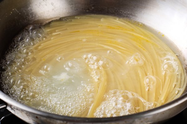spaghetti pasta boiling in hot water in satinless steel pan preparation for making al dente spaghetti - Кулинарные секреты для одиноких