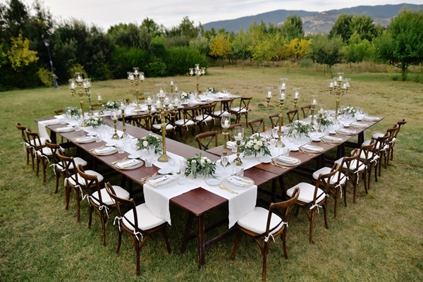 top view of decorated with minimal floral bouquets wedding celebration table with chiavari seats outdoors in the gardens with a mountain view - Рекомендации по расчёту банкетных блюд и напитков