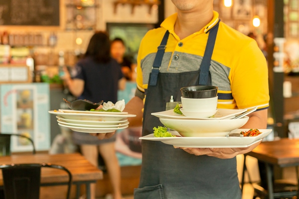 waiter removing dirty dishes from the tables in restaurant - Рекомендации по расчёту банкетных блюд и напитков
